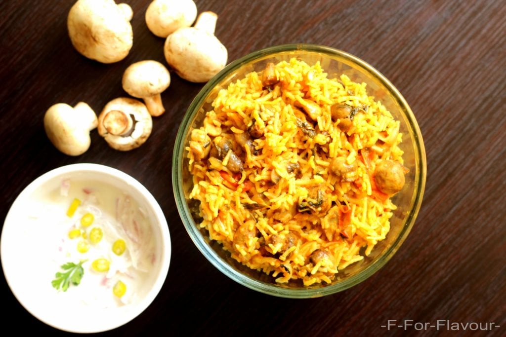 Mushroom Biryani in a bowl with onion raitha